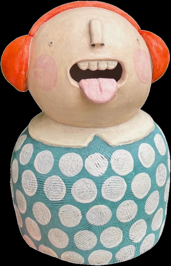 Figura de cerámica con orejeras naranjas y vestido de lunares